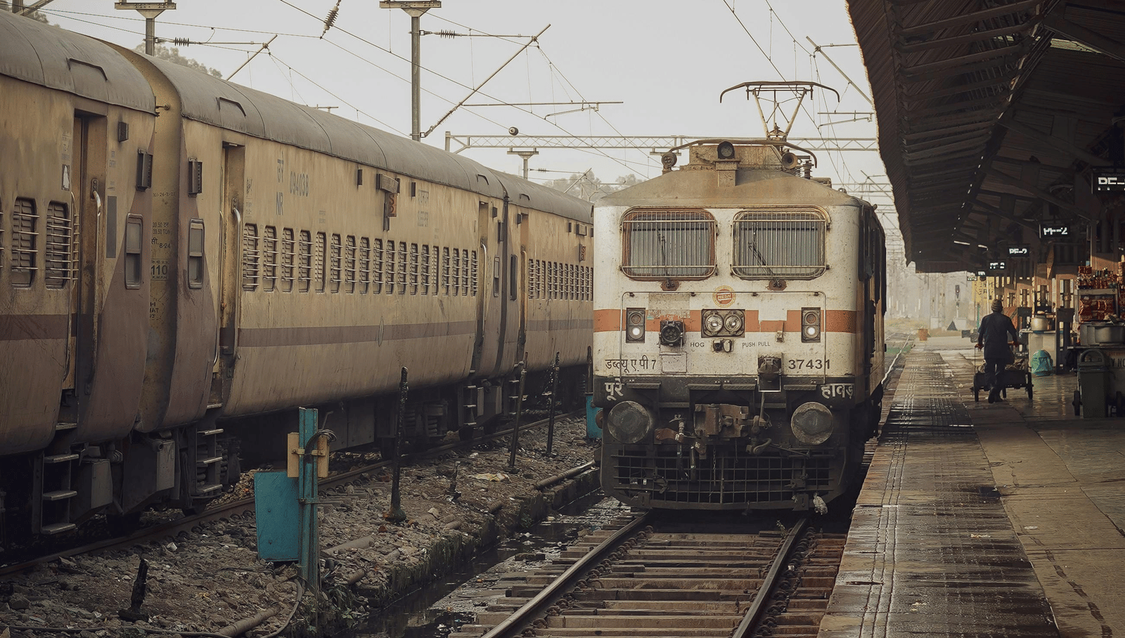 An indian railway locomotive stationed on a platform at a railway station.